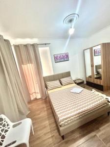 - une chambre avec un lit et une chaise blanche dans l'établissement Prodige meublées, à Abidjan