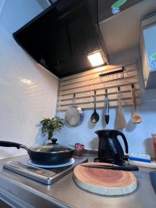a kitchen with a stove with a pot on a counter at Noah's Ark78 The Guesthouse Noah in Naha