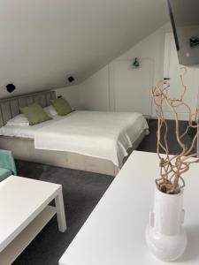 um quarto com duas camas e um vaso com uma planta em Izabelės apartamentai em Palanga