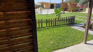 een houten hek naast een tuin met gras bij Chalé do Vale in Pinhal Novo