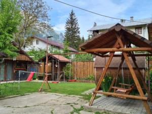 une aire de jeux dans une cour avec une maison dans l'établissement Casa Farcaș Bușteni, à Buşteni