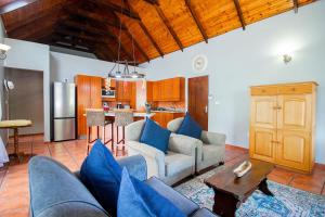 a living room with blue couches and a kitchen at Oom Ben in Paternoster +14 photos