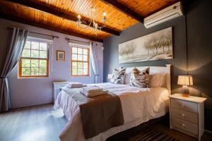 a bedroom with a bed and a painting on the wall at Oom Ben in Paternoster