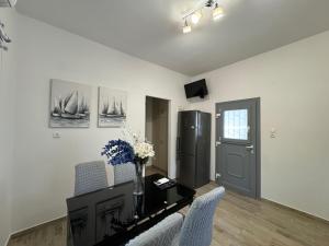 a living room with a table and chairs and a refrigerator at House on the beach Agia Anna Naxos in Agia Anna Naxos