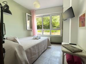 a bedroom with two beds and a window at Apartamentos Playa La Arena Encinar in Isla