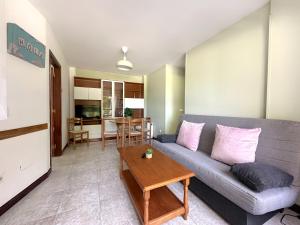 a living room with a couch and a table at Apartamentos Playa La Arena Encinar in Isla