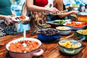 a group of people holding plates of food on a table at Abraham Tel Aviv in Tel Aviv
