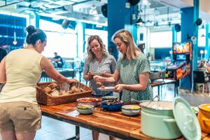 three women standing in a kitchen preparing food at Abraham Tel Aviv in Tel Aviv