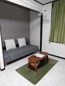 a living room with a couch and a coffee table at Noah's Ark78 The Guesthouse Noah in Naha