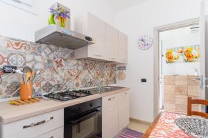 a kitchen with a sink and a stove top oven at Appartamento di Stefy by BarbarHouse in Torre Lapillo