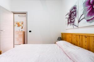 a bedroom with a white bed and flowers on the wall at Appartamento di Stefy by BarbarHouse in Torre Lapillo