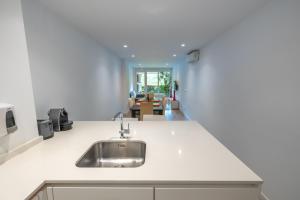 a kitchen with a sink and a living room at Zona Hospitales y Clinica Universitaria - TuApartamento in Pamplona