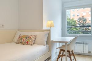 um quarto com uma cama, uma secretária e uma janela em Zona Hospitales y Clinica Universitaria - TuApartamento em Pamplona