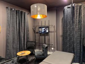 a living room with a couch and a table and a tv at love Room claire 1 - climatisation in Lyon