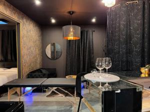 - un salon avec une table et deux verres à vin dans l'établissement love Room claire 1, à Lyon