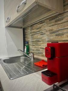 una encimera con fregadero y un aparato rojo en Maison Aretusa, en Siracusa