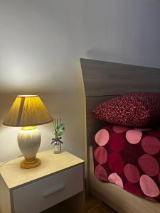 una lámpara en una mesita de noche junto a una cama en Maison Aretusa, en Siracusa 10 fotos más
