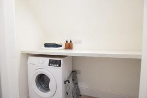 a washer and dryer under a counter in a room at Stylish city centre 1 bed apartment in Lincolnshire