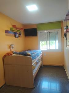 Kleines Zimmer mit einem Bett und einem Fenster in der Unterkunft Suite en 1a línea de Playa con piscina a 20 minutos de Barcelona in Premiá de Mar