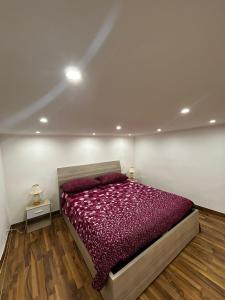 1 dormitorio con 1 cama con edredón morado en Maison Aretusa, en Siracusa
