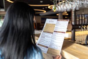 een vrouw in een bar met een menu bij Canyon Hotell in Alta