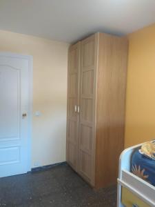 a bedroom with a wooden cabinet next to a bed at Primera línea de mar y piscina a 20 minutos de Barcelona in Premiá de Mar