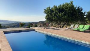 una piscina con sillas, mesa y árboles en Casa Montaña Vélez-Málaga B&B, en Vélez-Málaga