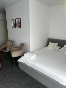 um quarto com uma cama, uma mesa e cadeiras em Izabelės apartamentai em Palanga