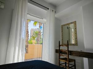 a bedroom with a window and a bed and a mirror at Aldea de Meer in Torrevieja