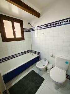 a bathroom with a toilet and a tub and a sink at Aldea de Meer in Torrevieja +14 photos