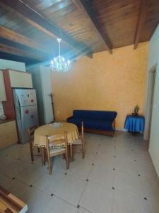 a living room with a table and a blue couch at Silver Coast Cottage Raches in Kouvéla