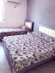 a bedroom with two beds with a quilt on it at Red Sunset Apartment in Himare