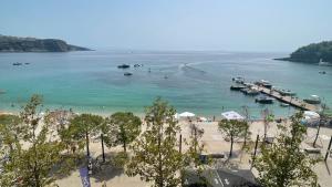 a view of a beach with boats in the water at Red Sunset Apartment in Himare