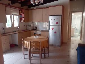 a kitchen with a table and a white refrigerator at Silver Coast Cottage Raches in Kouvéla