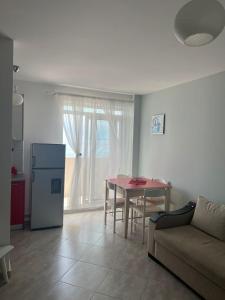 a living room with a couch and a table at Red Sunset Apartment in Himare