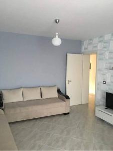 a living room with a couch and a wall at Red Sunset Apartment in Himare