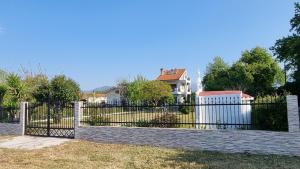 a black fence in front of a white house at Silver Coast Cottage Raches in Kouvéla