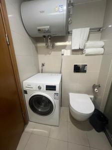 ein Badezimmer mit einer Waschmaschine und einem WC in der Unterkunft Lujiazui More Residence in Shanghai