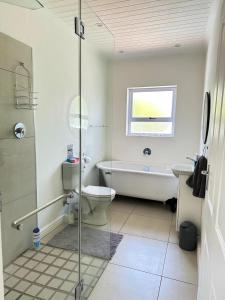 a bathroom with a tub and a toilet and a sink at The Dunes in Yzerfontein