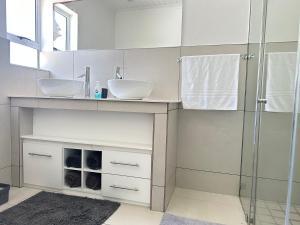 a bathroom with two sinks and a shower at The Dunes in Yzerfontein +11 photos