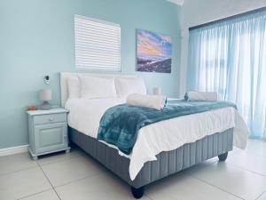 a bedroom with a large bed and a window at The Dunes in Yzerfontein
