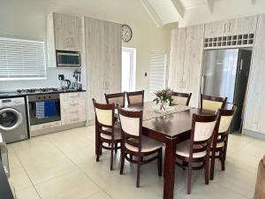 a kitchen with a dining room table and chairs at The Dunes in Yzerfontein