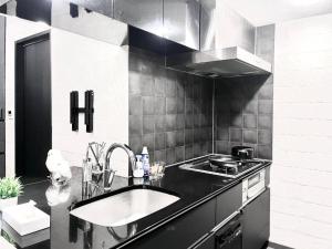 a kitchen with a sink and a stove at Shibuya Harajuku Big House in Tokyo +8 photos