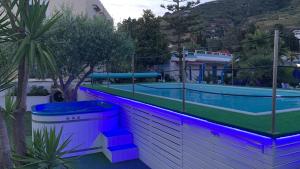 una grande piscina con illuminazione viola e blu di Hotel Casa Adolfo Ischia a Ischia