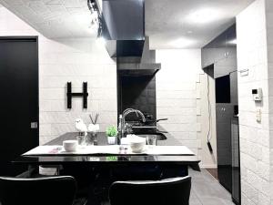 a kitchen with a sink and a counter with chairs at Shibuya Harajuku Big House in Tokyo