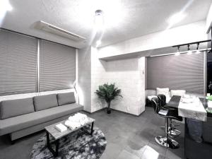 a living room with a couch and a table at Shibuya Harajuku Big House in Tokyo