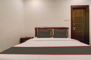 a bed with two pillows on it in a room at Super Collection O Halcyon Madhapur in Hyderabad