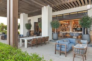 een terras met tafels en stoelen en een bar bij Palace Beach Resort Fujairah in Fujairah