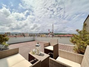 a patio with chairs and tables on a roof at CRISTINCO PANORAMIC in Cluj-Napoca