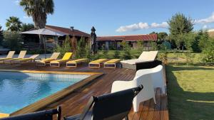 una terraza con tumbonas y una piscina en Chalé do Vale, en Pinhal Novo